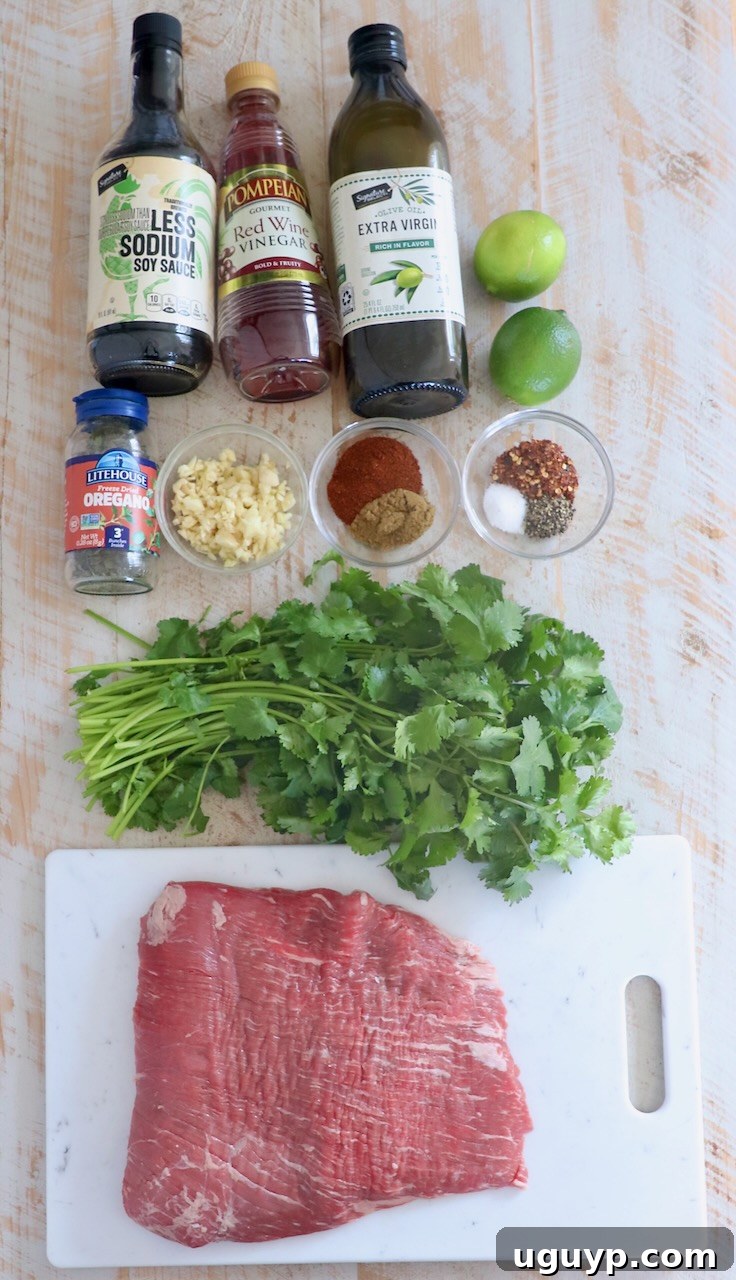 flank steak taco ingredients on white wood board