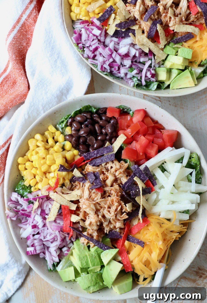 Two bowls of BBQ Chicken Salad with forks, showcasing the vibrant ingredients.