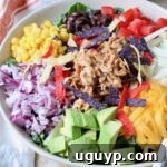 BBQ Chicken Salad in a bowl topped with shredded bbq chicken and vegetables