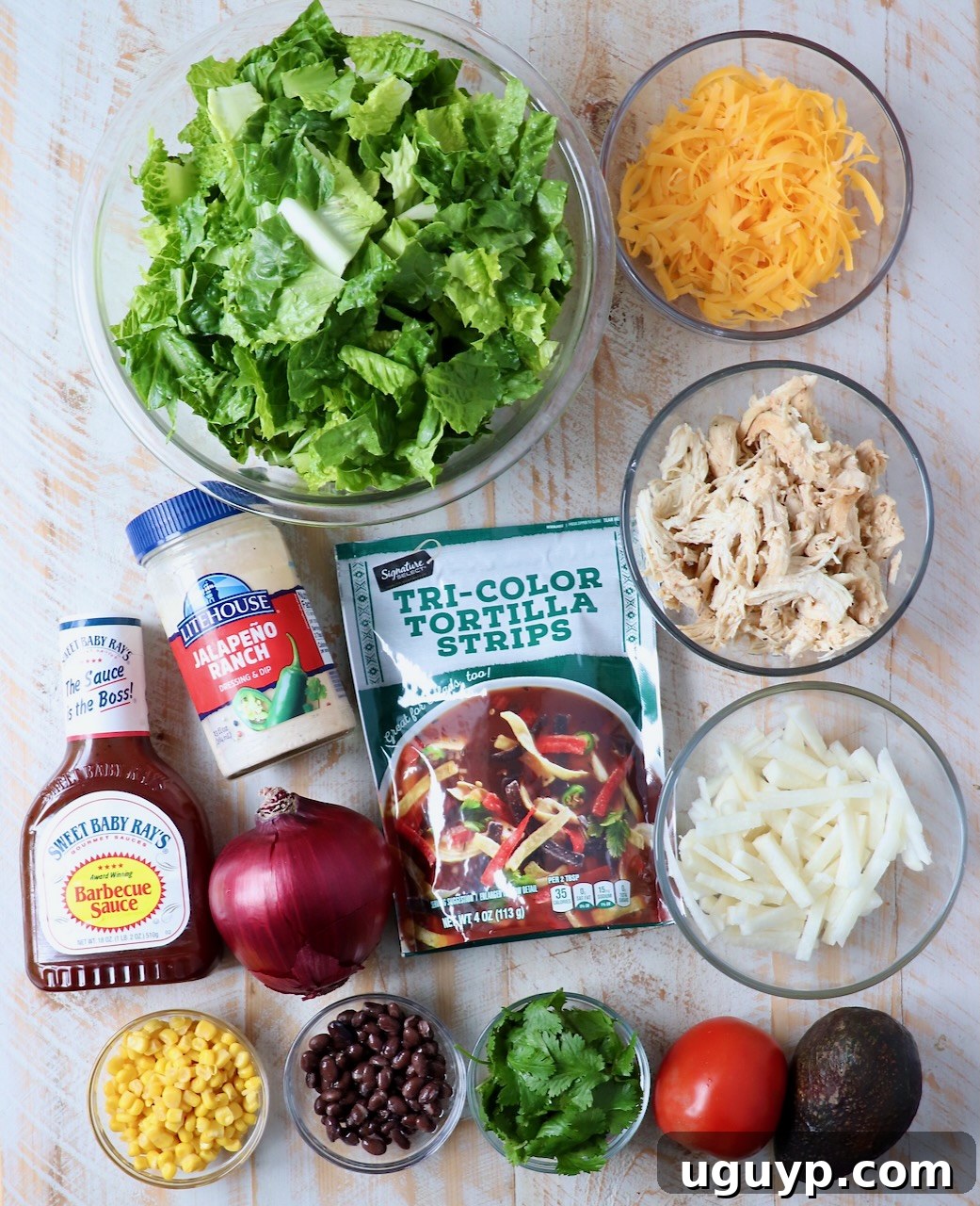 Ingredients for homemade BBQ Chicken Salad laid out on a white wooden board.