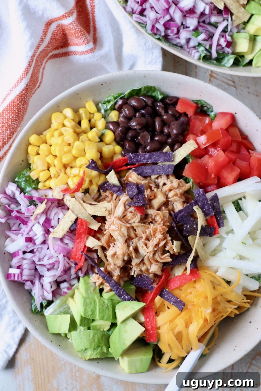 Close-up of a single bowl of BBQ Chicken Salad with a fork, ready to eat.