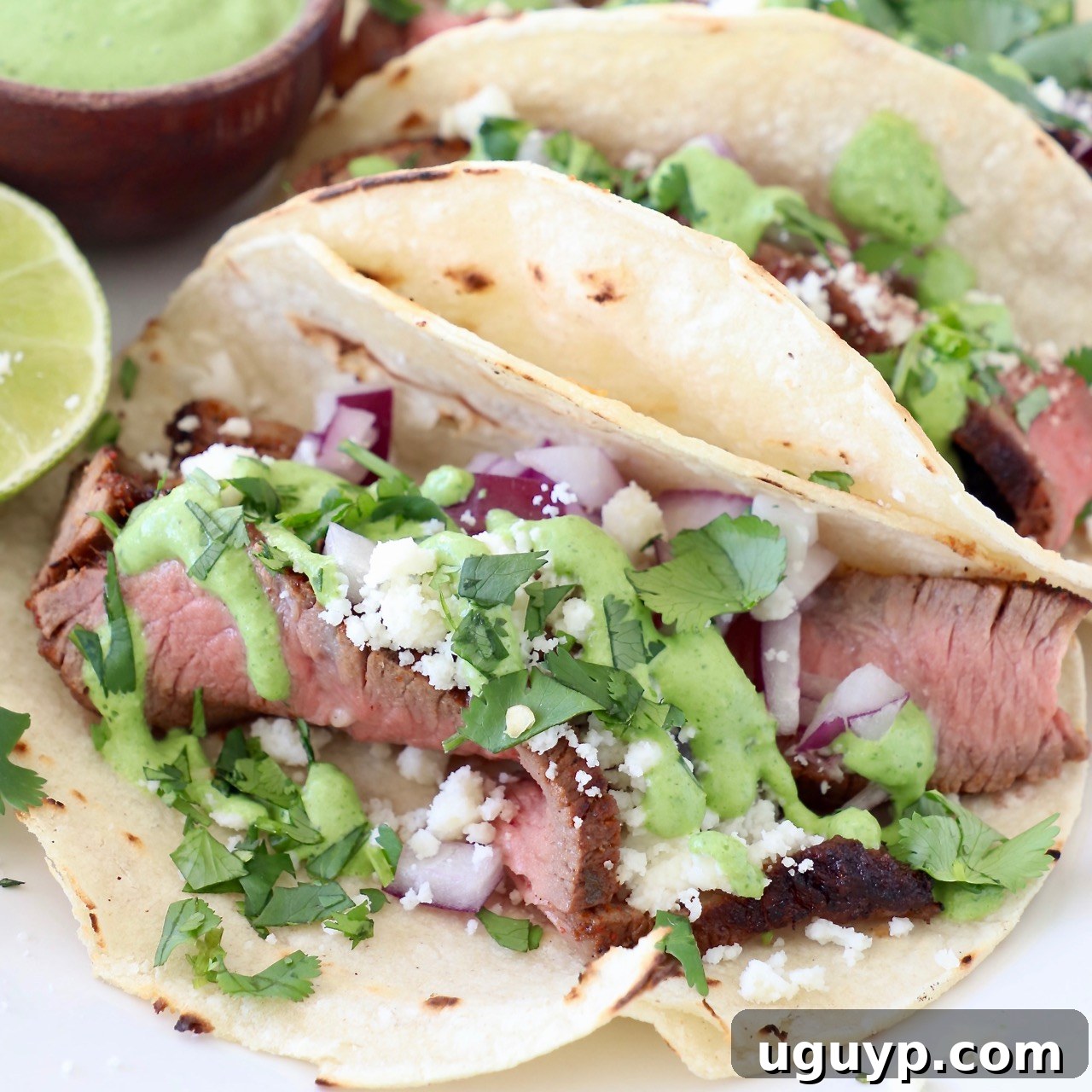 steak tacos on plate with lime and cilantro