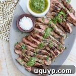 sliced skirt steak on plate topped with chimichurri sauce