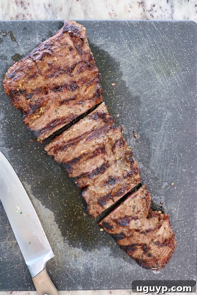 Grilled skirt steak sliced into three large pieces, showing the grain