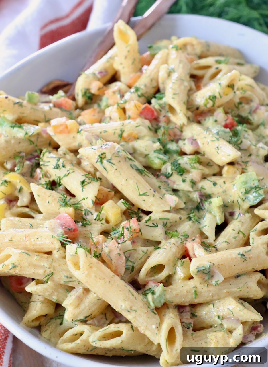 creamy pasta salad tossed with Greek yogurt dressing in a large serving bowl, garnished with fresh dill