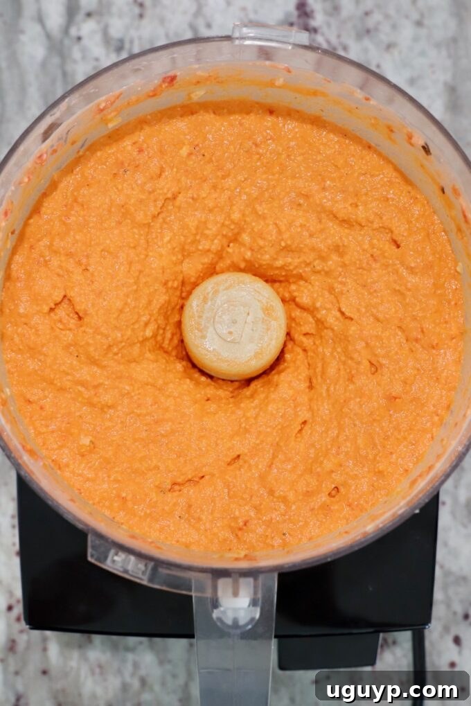 Spicy feta dip, fully blended to a smooth and creamy consistency, inside a food processor bowl, ready to be transferred.