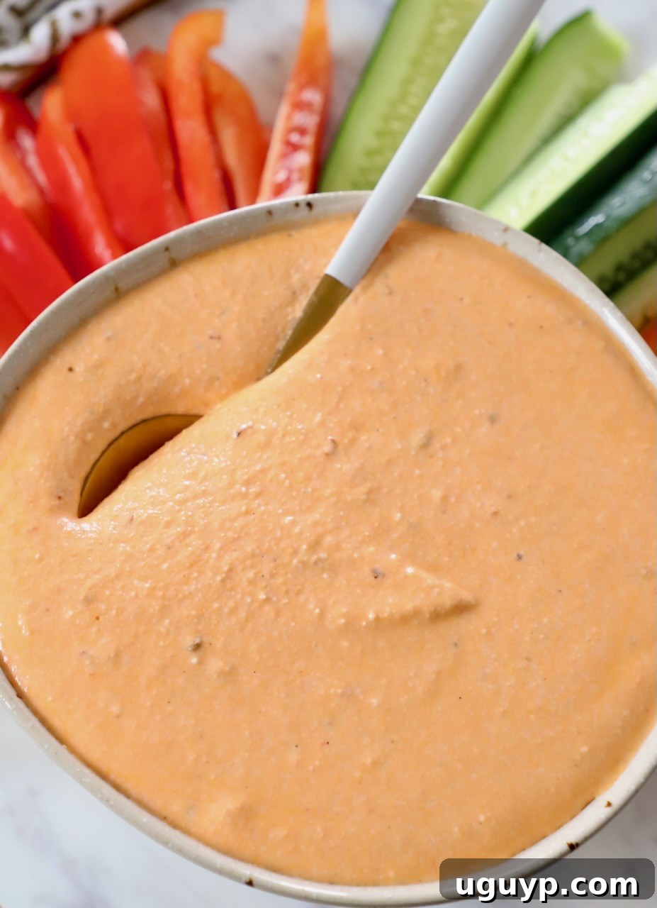 Spicy feta dip in a rustic bowl, garnished with fresh herbs and a spoon, ready to be served.