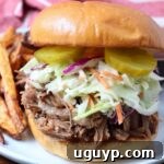 Pulled pork sandwich on a plate with French fries