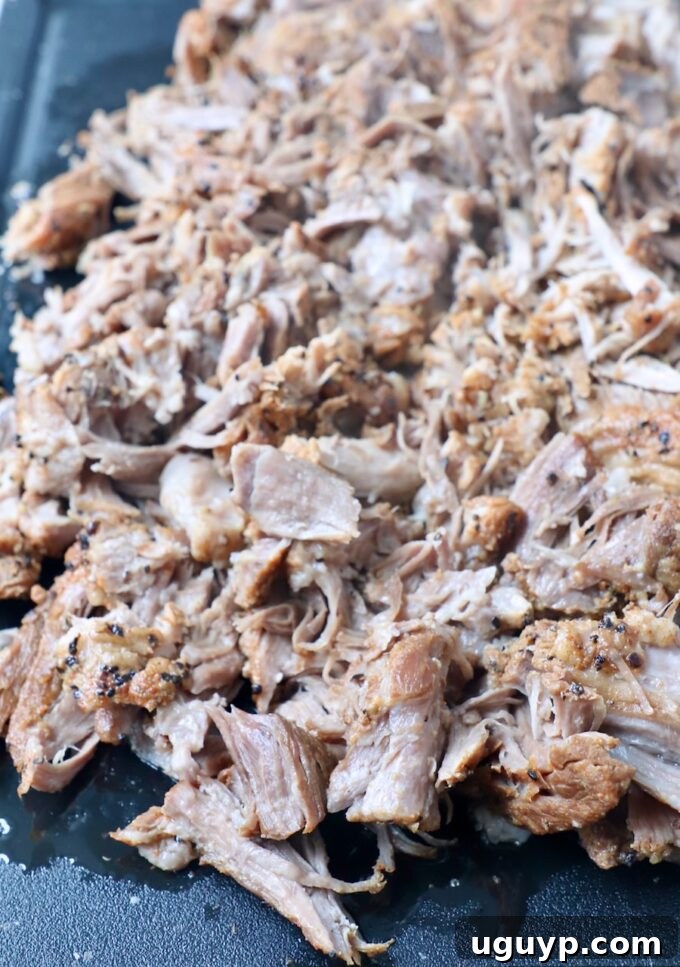 Shredded pork shoulder on a cutting board, ready to be served