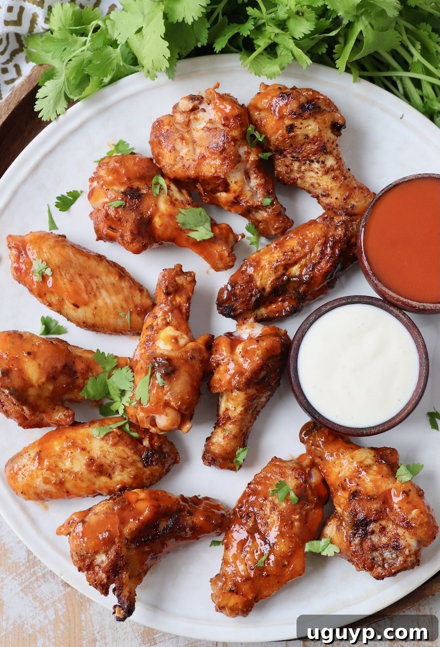 A generous plate of grilled chicken wings, glistening with buffalo sauce, perfect for a spicy kick.