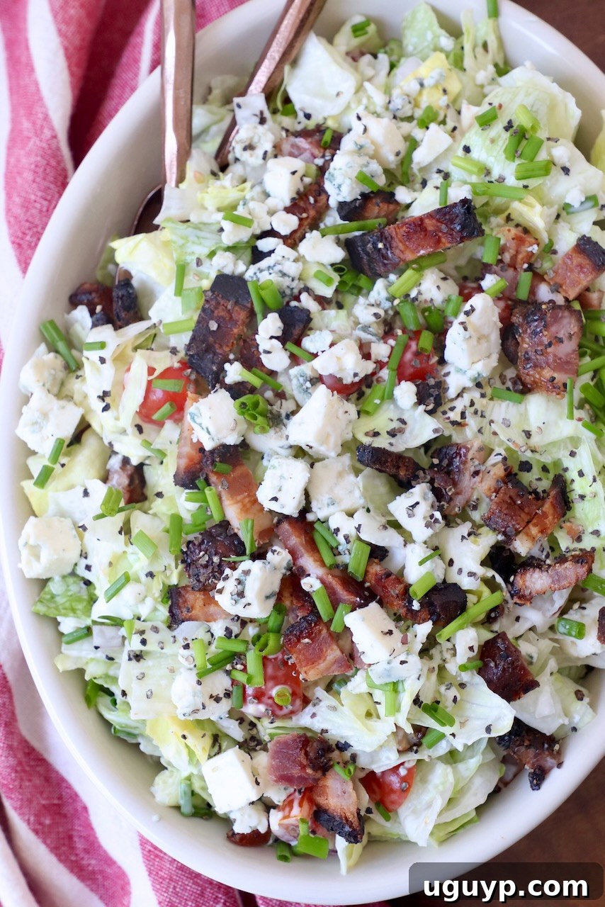 chopped salad in bowl topped with bacon and blue cheese