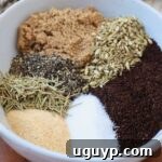 A small bowl featuring a finely textured blend of ground coffee, brown sugar, and various herbs and spices, ready to be used as a steak rub.
