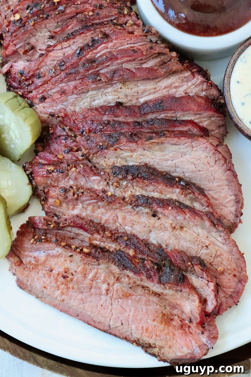 Perfectly sliced smoked tri tip roast on a plate, showcasing its juicy interior and smoky crust.