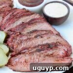 Sliced smoked tri tip on plate with bowls of bbq sauce