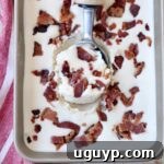A close-up of a scoop of Maple Bacon Ice Cream in a metal container