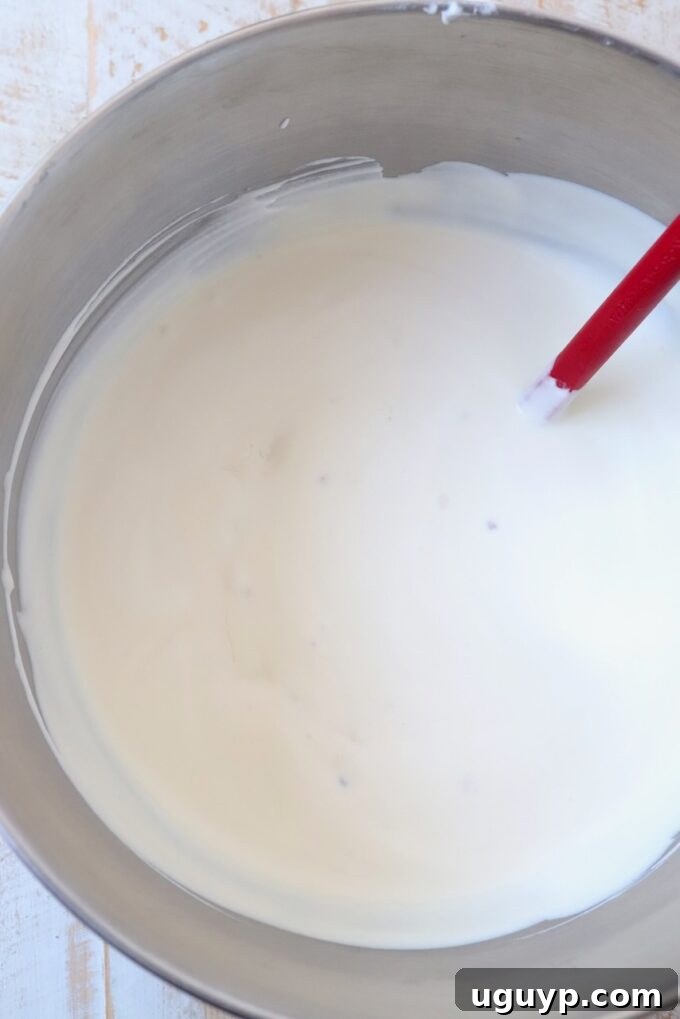 Maple bacon ice cream base in a large mixing bowl, showing its smooth and creamy texture before freezing