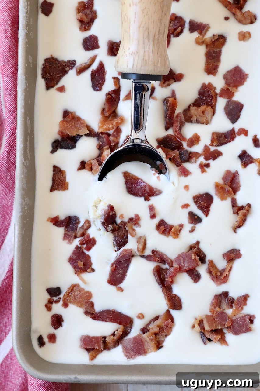 Maple bacon ice cream beautifully scooped into a metal container, showing its creamy texture