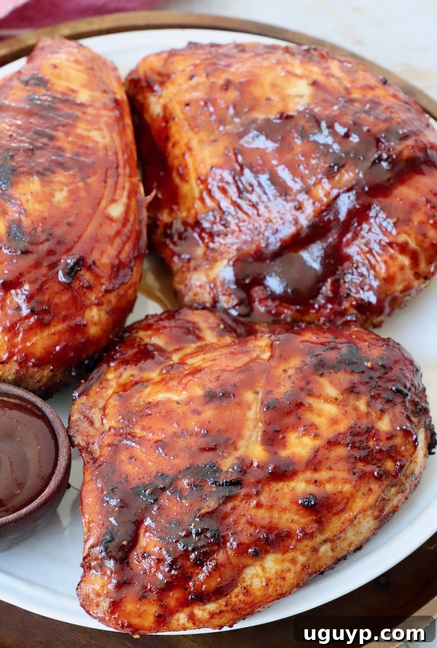 Plates of bone-in BBQ chicken breasts, perfectly seasoned and grilled, showcasing a beautiful, caramelized crust.