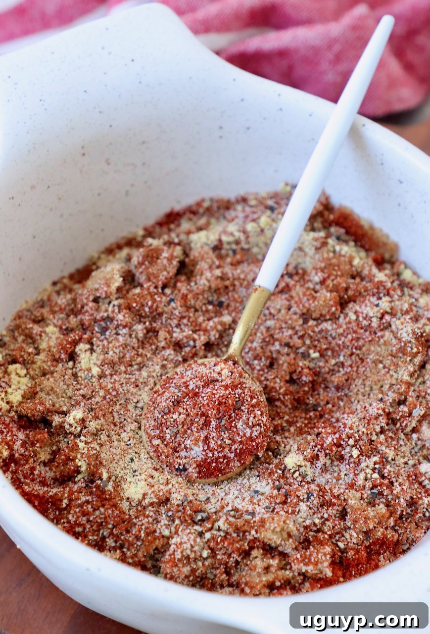 A beautiful bowl of homemade BBQ seasoning blend, with a small spoon resting inside, ready to add flavor to any dish.
