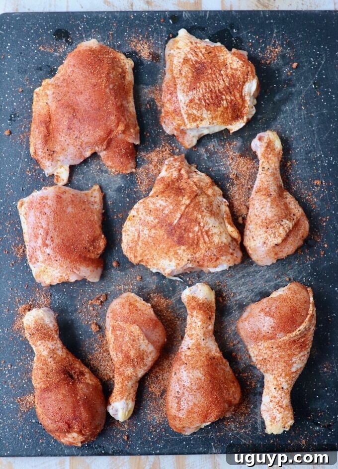 Seasoned bone-in chicken pieces resting on a cutting board, ready for grilling.