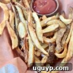 cooked french fries in basket with side bowl of ketchup