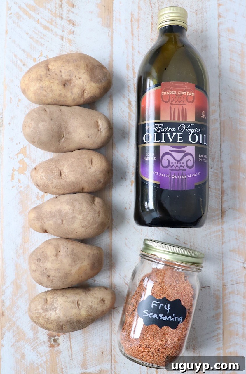 ingredients for homemade french fries on white wood board