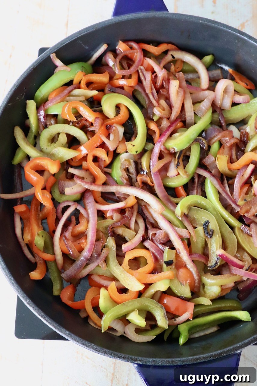 cooked sliced bell peppers and onions in large skillet