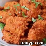 boneless chicken wings tossed in buffalo sauce on plate