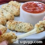 hands pulling apart a mozzarella stick