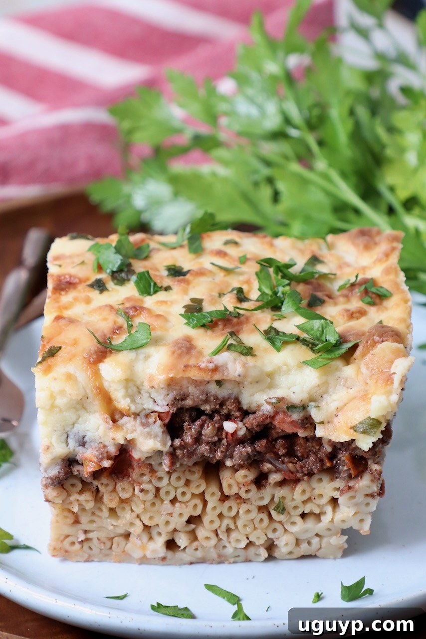 slice of pastitsio on plate with fresh parsley