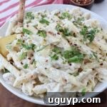 Garlic parmesan chicken pasta in a bowl with a serving spoon.