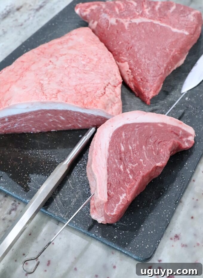 A thick slice of picanha steak with a sharp metal skewer inserted, creating a pilot hole.