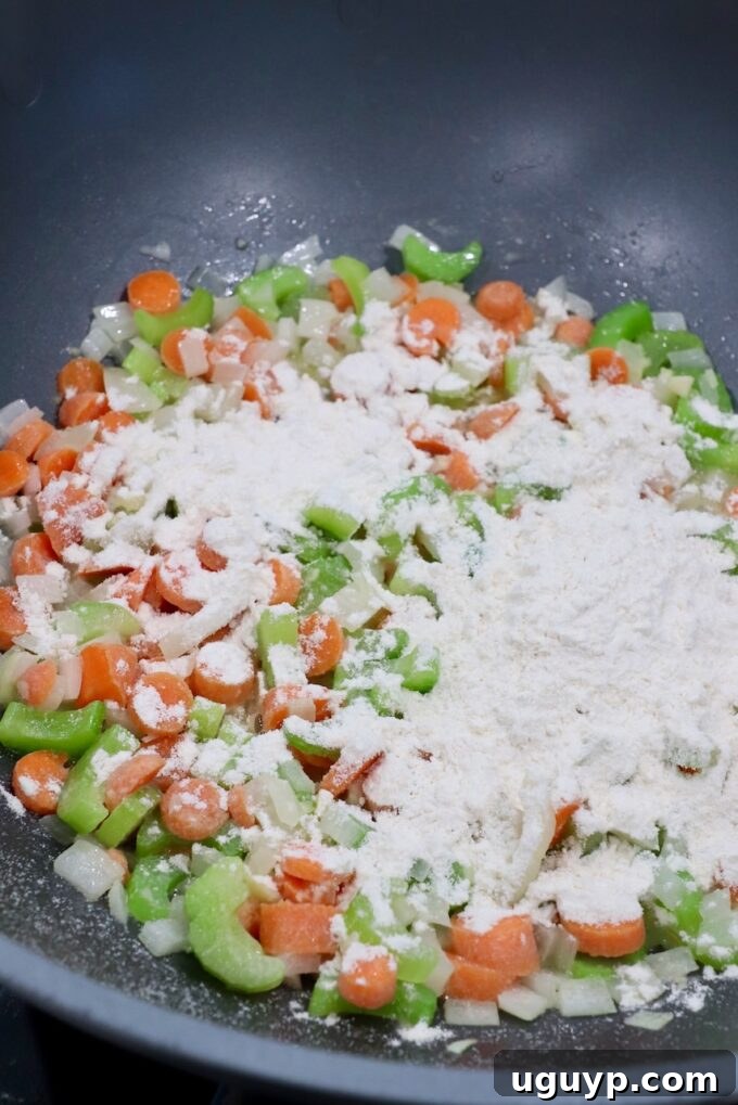 A light dusting of all-purpose flour sprinkled over tender diced vegetables in a large skillet