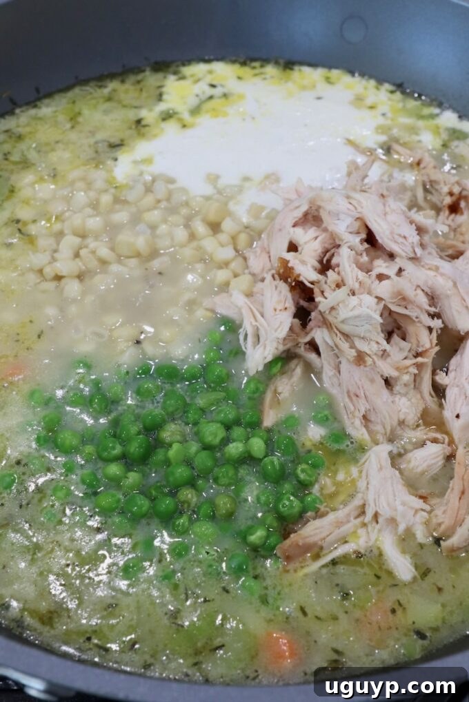 Hearty chicken pot pie soup simmering to perfection in a large pot on the stove