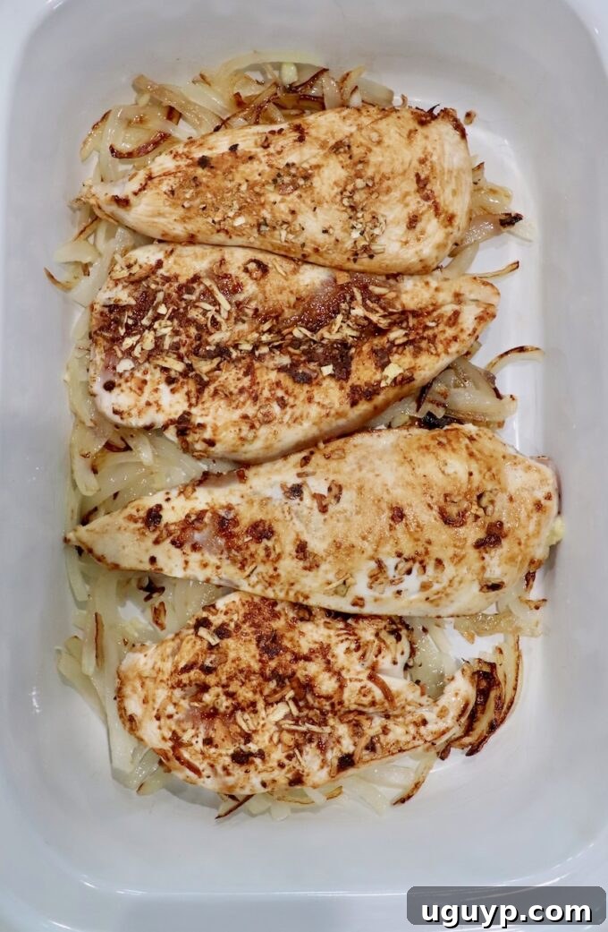 seasoned, seared chicken breasts in slow cooker with caramelized onions