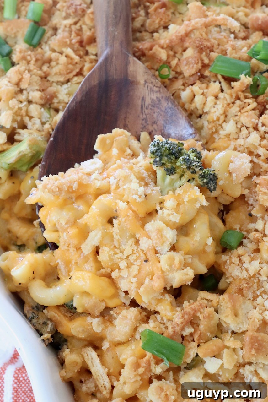 baked broccoli mac and cheese in casserole dish with large serving spoon