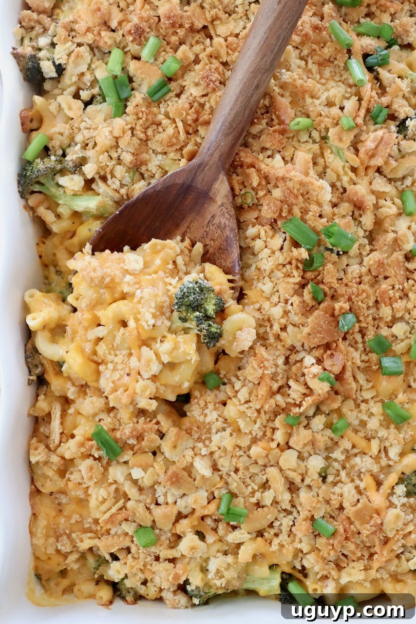 baked broccoli mac and cheese in casserole dish with serving spoon