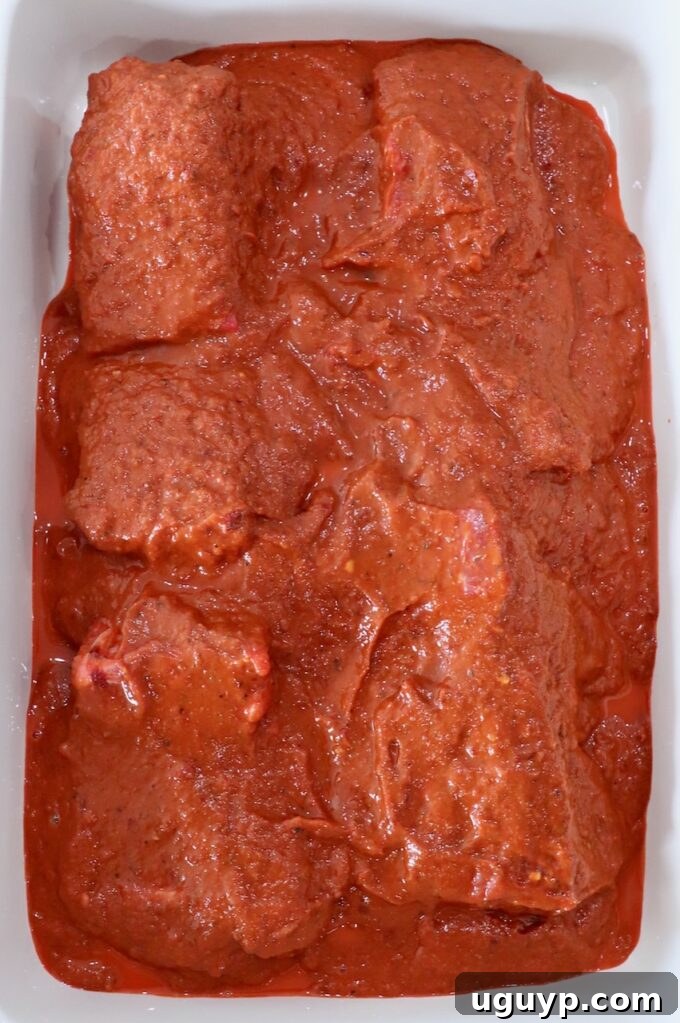 beef covered in rich vinegar tomato chili marinade in large casserole dish