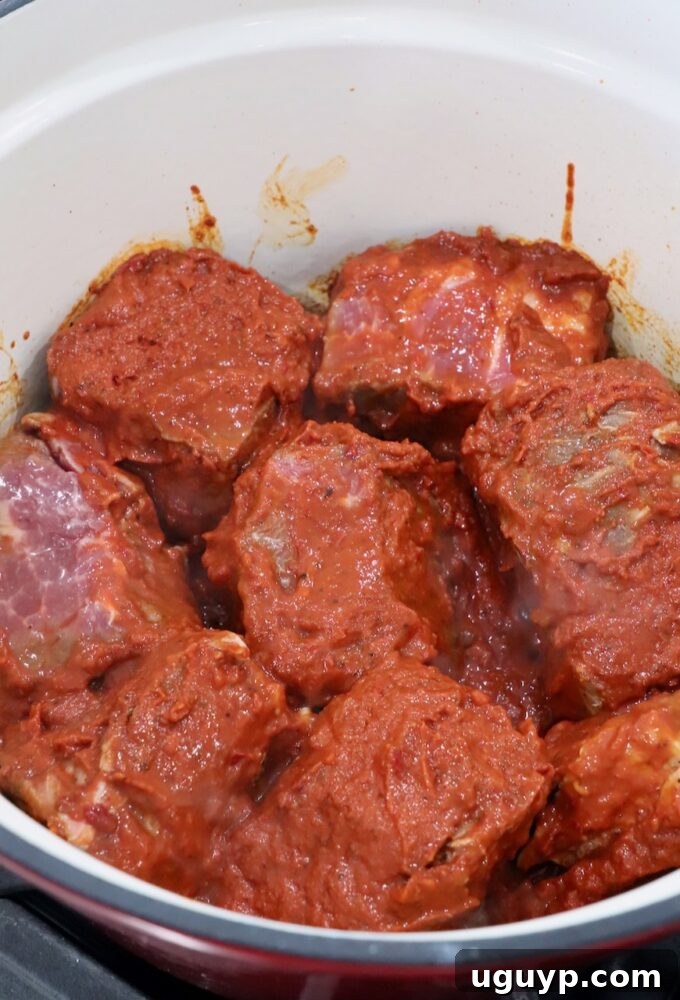 marinated chunks of beef in large dutch oven, ready for searing