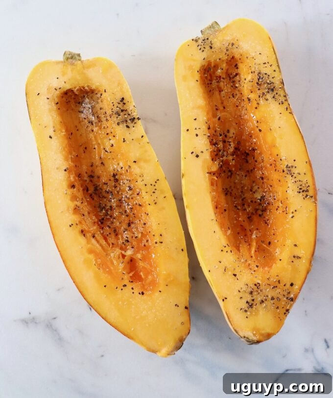 delicata squash cut in half with the seeds removed and seasoned with salt and pepper