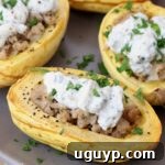 Roasted delicata squash cut in half and filled with chicken sausage and ricotta cheese, a delicious fall meal.