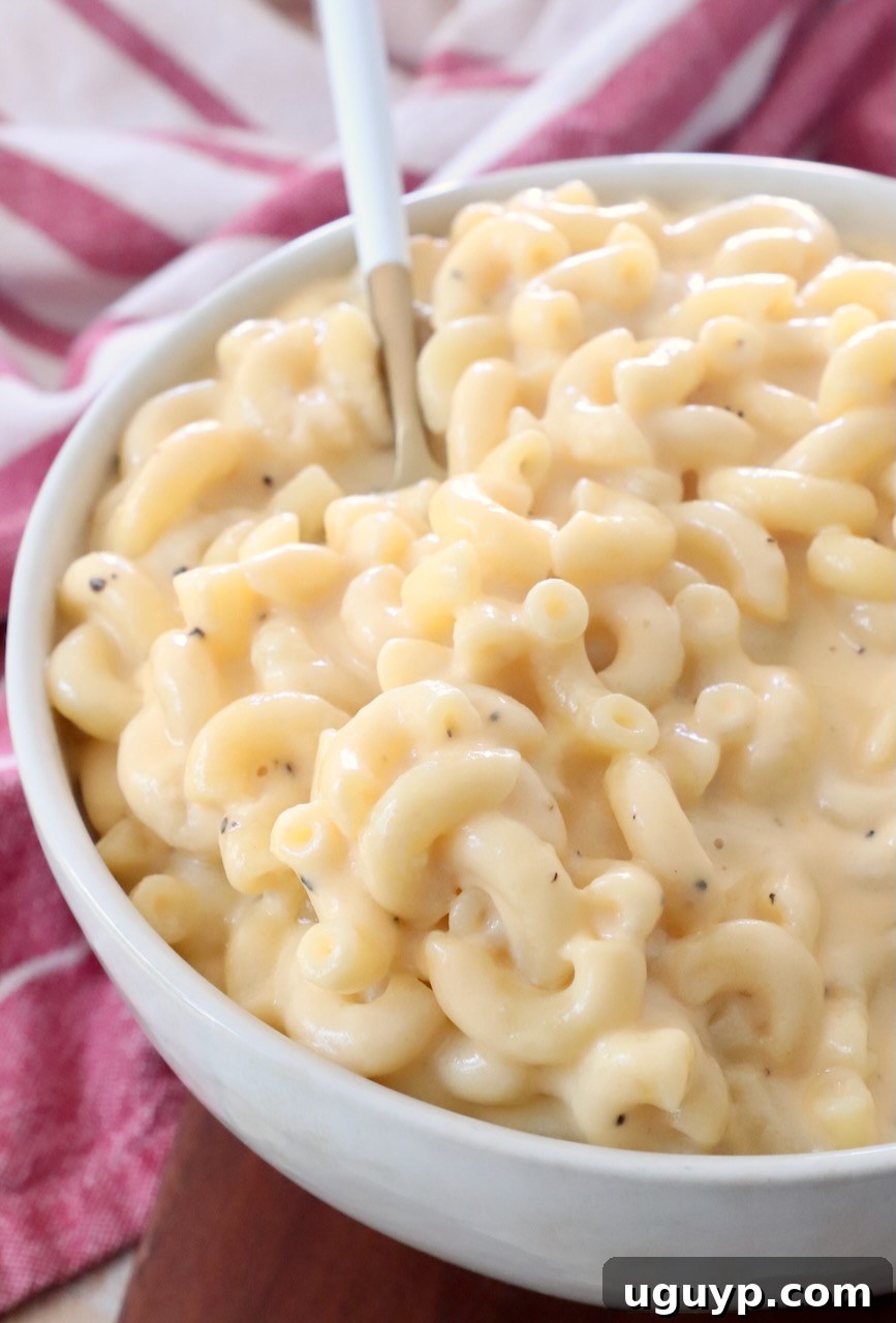 A large bowl of creamy stovetop mac and cheese with a fork resting in it, ready to be enjoyed.