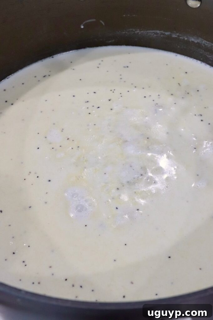A creamy, smooth sauce beginning to form in a large pot, indicating the successful creation of a roux and the start of the cheese sauce.