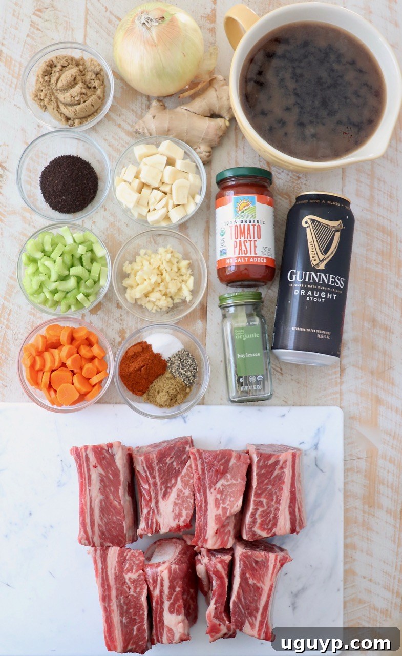 Fresh ingredients laid out for making Guinness braised short ribs, including short ribs, vegetables, spices, and Guinness stout.