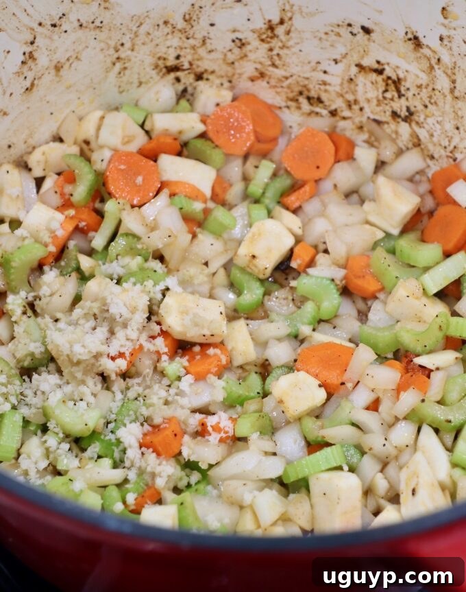 Diced onions, carrots, parsnips, celery, garlic, and ginger sautéing in a Dutch oven to build the braising liquid base.