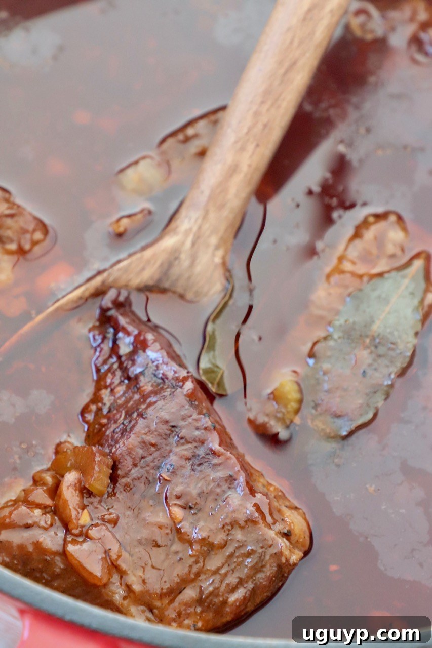 Deliciously braised short ribs in a Dutch oven, glistening with rich sauce, ready to be served.
