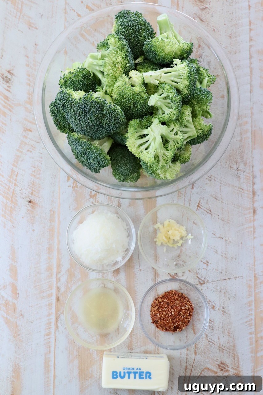 Ingredients for Smashed Broccoli laid out on a white wooden board