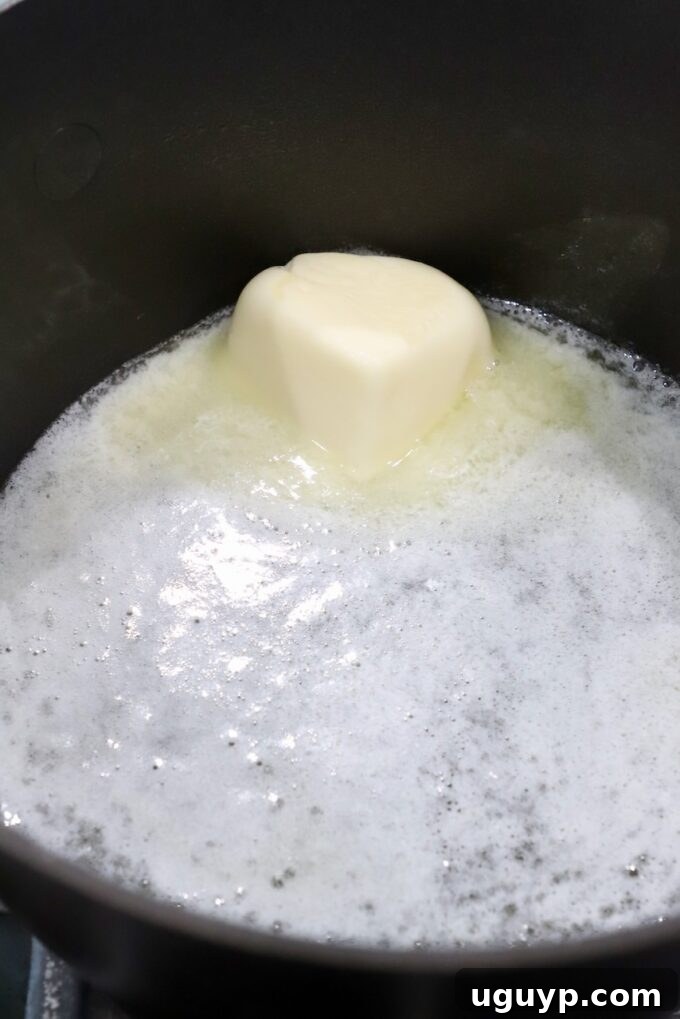 Melted unsalted butter in a small saucepan on the stove