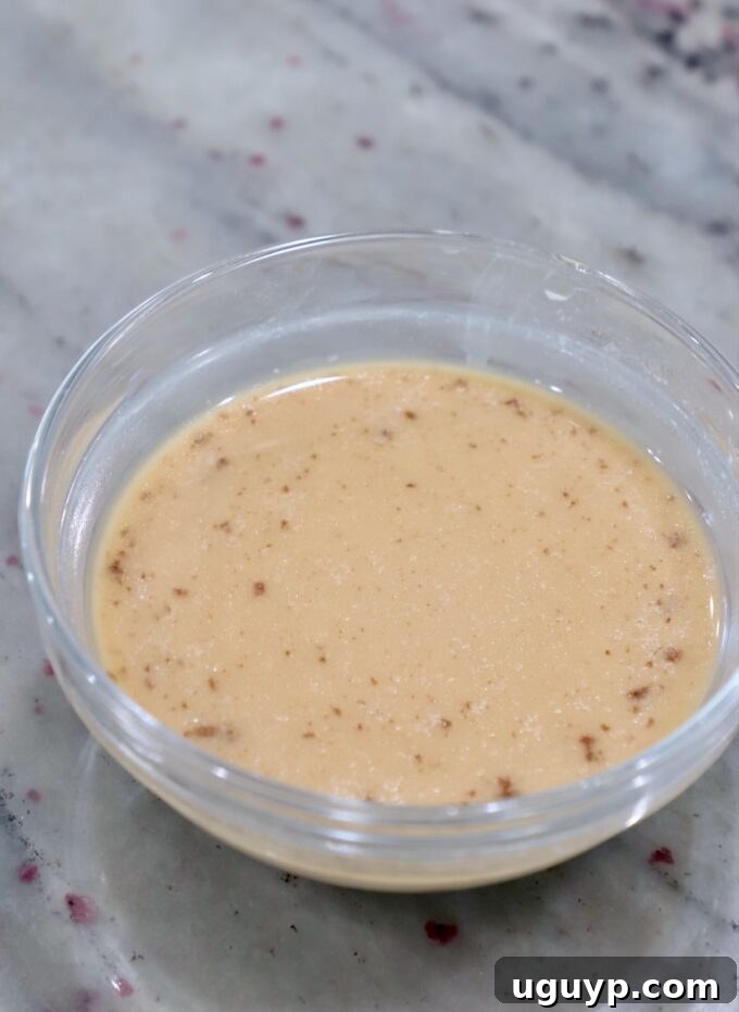 Beef broth and cornstarch slurry in a small bowl, ready to thicken the sauce.