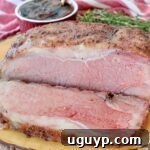 Sliced, perfectly cooked New York Strip Roast on a wooden board.